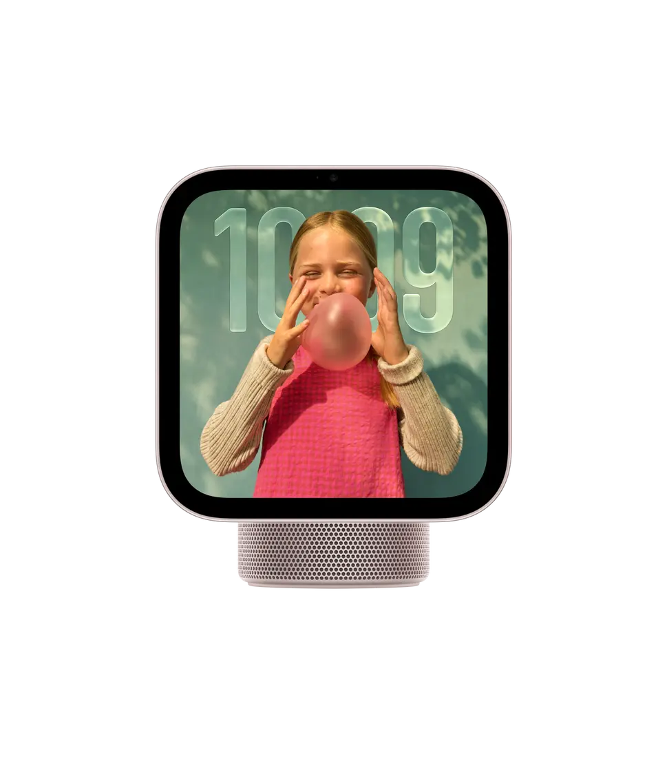 Apple HomeView, display with base, rose pink. Front exterior, square display, rounded corners, flat sides, black display bezel, centred top camera, cylindrical speaker base with circular perforations